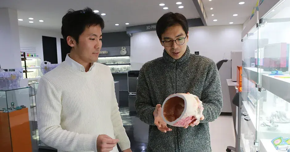 Due colleghi osservano una stampa 3D