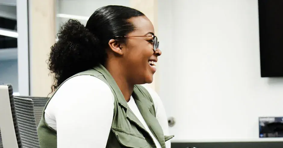 una collega sorridente siede a un tavolo