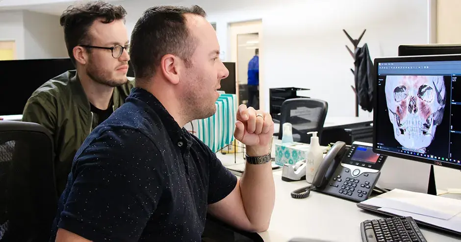 Due colleghi seduti davanti a un computer desktop