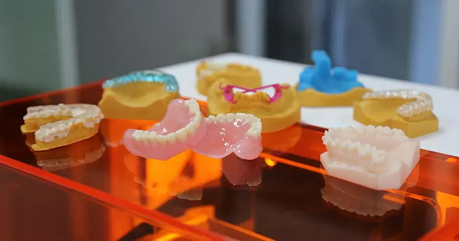 un assortimento di stampi, protesi e parti odontoiatriche stampati in 3D