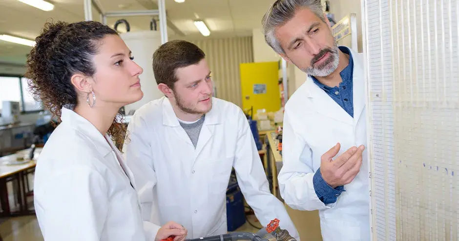 3 persone in piedi in una struttura discutono di lavoro