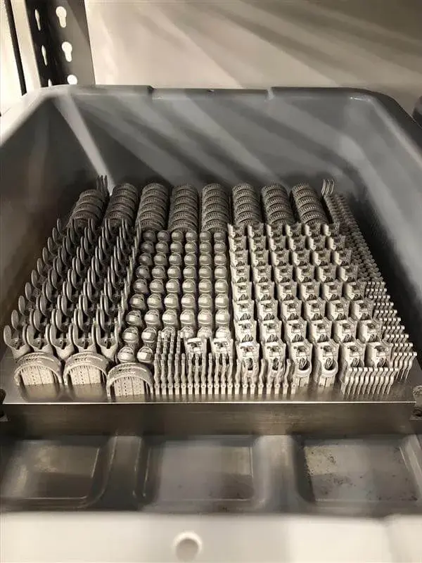 Vassoio di costruzione pieno di parti metalliche stampate in 3D per le protesi parziali della mano di Point Designs