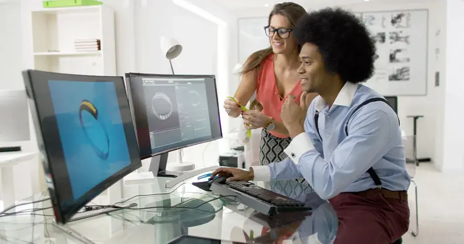 2 persone progettano un orologio e modificano il file su un grande monitor