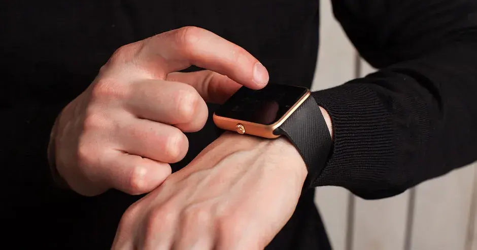 uomo che indossa un orologio e ne indica le funzioni