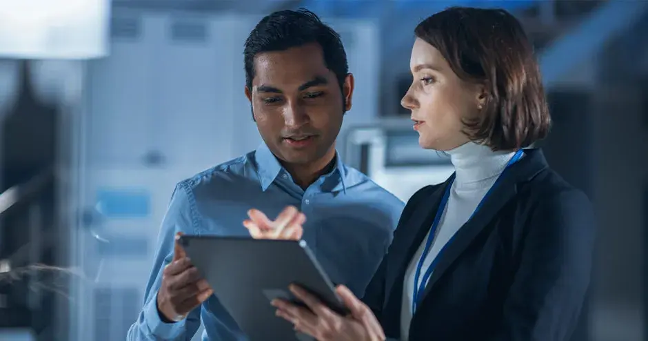 Due persone che lavorano insieme su un tablet in un contesto industriale