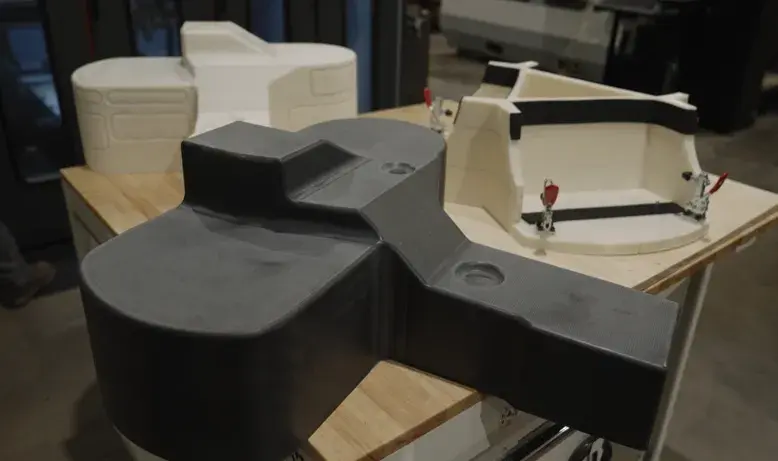 Uno stampo per termoformatura in CF-PC stampato in 3D e lavorato, un prototipo in ABS stampato in 3D di una parte formata, nonché e un dispositivo di rifinitura in ABS stampato in 3D, tutti prodotti sul sistema EXT 1270 Titan Pellet di 3D Systems. 