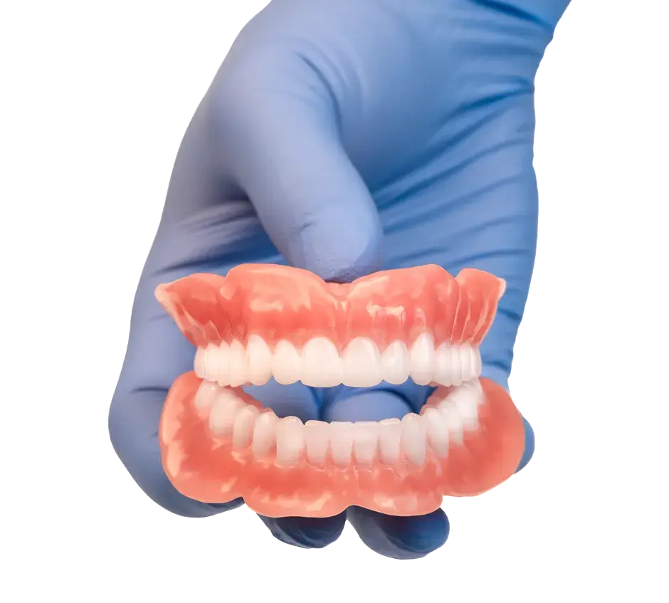 Una mano con un guanto medico che mostra protesi dentarie stampate in 3D