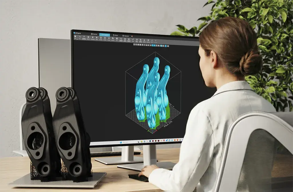 A woman sitting at a desk looking at 3D Sprint software on a desktop computer